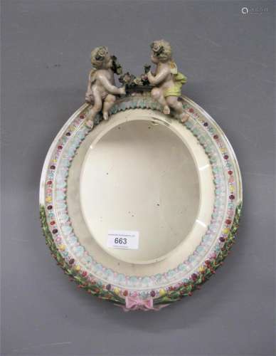 German porcelain oval mirror surmounted by two figures of ch...