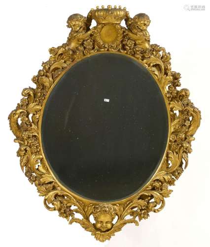 Grand miroir ovale en bois sculpté et doré à décor floral, d...