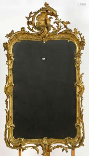 Grand miroir de style Louis XV en bois sculpté et doré. (* e...
