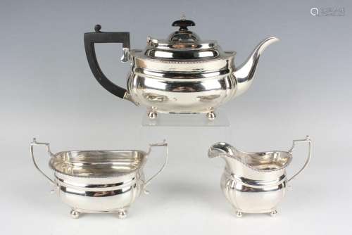 A George V silver cushion shaped three-piece tea set with ga...