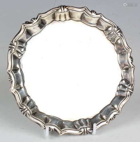 A George II silver card salver with raised piecrust, scroll ...