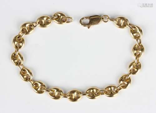 A gold anchor and oval link bracelet on a sprung hook shaped...