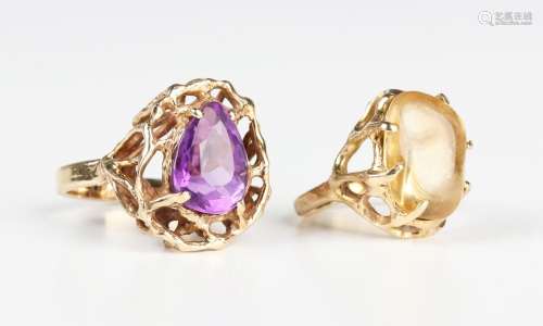 A gold and amethyst single stone ring in a pierced rustic de...