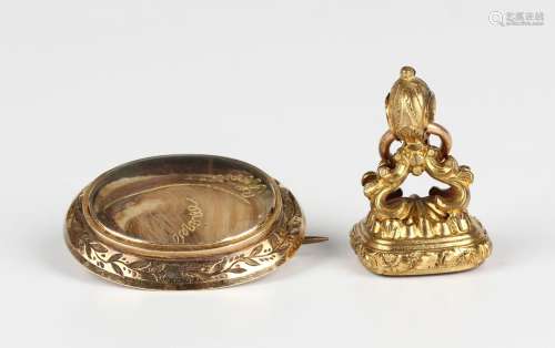 A Victorian gold cased oval mourning brooch, the front glaze...