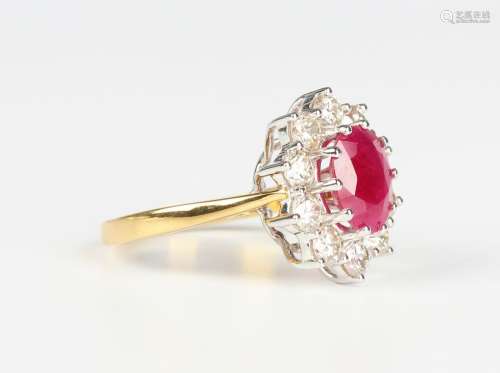 An 18ct gold, ruby and diamond oval cluster ring, claw set w...