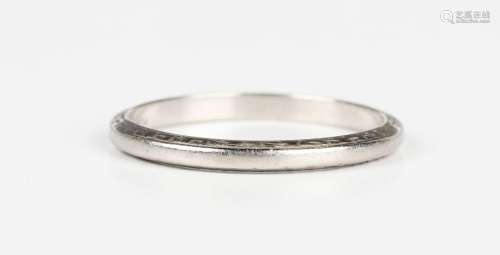 A platinum wedding ring, the sides with engraved decoration,...