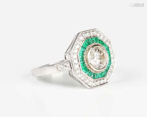 A white gold, emerald and diamond octagonal cluster ring, co...