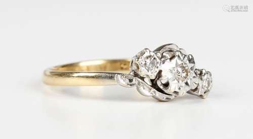 An 18ct gold and diamond three stone ring in a twistover des...