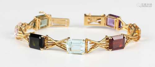 A gold and varicoloured gemstone bracelet, claw set with a r...