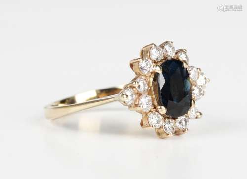 A gold, sapphire and diamond cluster ring, claw set with an ...