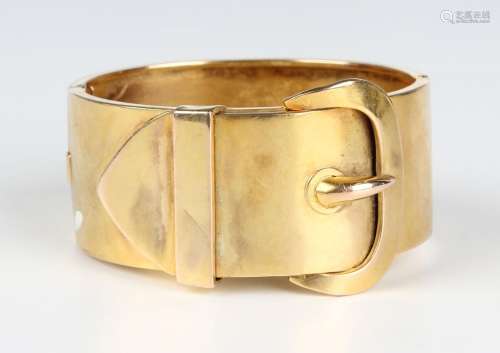 A Victorian gold oval wide hinged bangle, the front with a b...