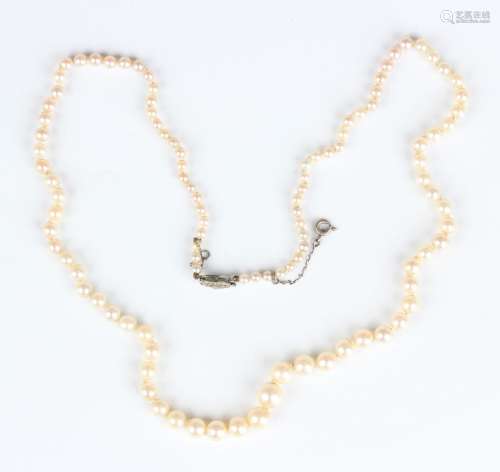 A single row necklace of graduated cultured pearls on an ova...