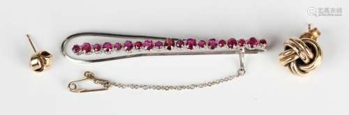 A white gold and ruby tie slide, mounted with a row of vario...