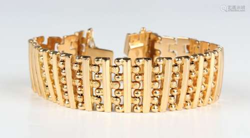 A gold wide bracelet in a bar and beaded link design, on a s...