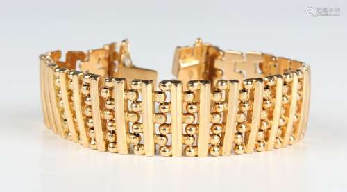 A gold wide bracelet in a bar and beaded link design, on a s...