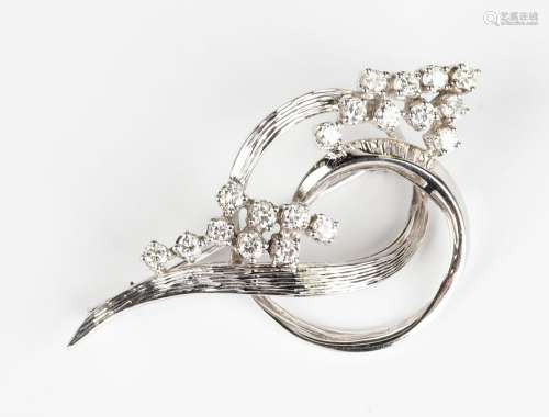 A white gold and diamond brooch in an interlooped scrolling ...