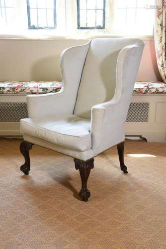 A GEORGE II CARVED WALNUT AND UPHOLSTERED WING ARMCHAIR, CIR...