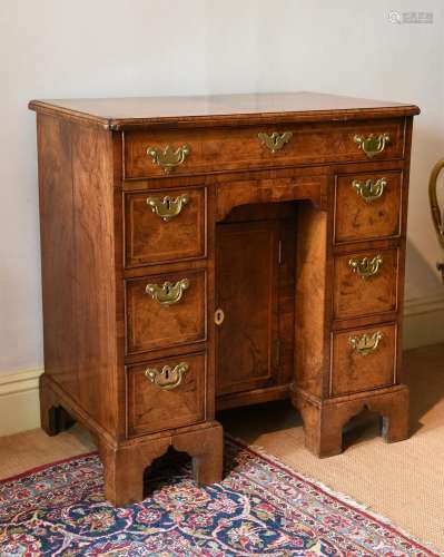 A GEORGE II FIGURED WALNUT AND FEATHER BANDED KNEEHOLE DESK,...