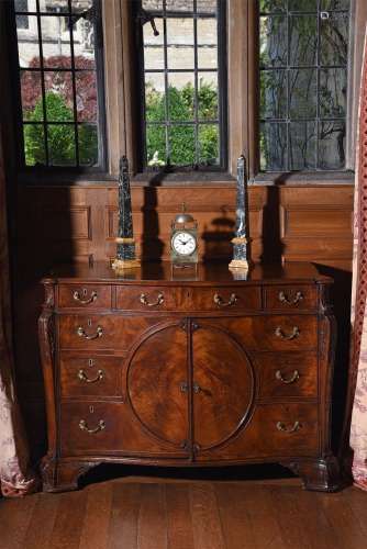 A GEORGE III FIGURED MAHOGANY SERPENTINE COMMODE, IN THE MAN...