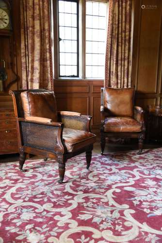 A PAIR OF MAHOGANY LIBRARY BERGERE ARMCHAIRS, IN REGENCY STY...