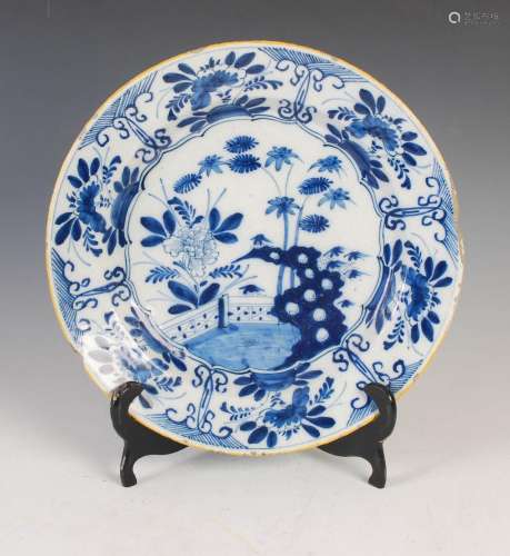 A 19th century Delft pottery charger, decorated with fenced ...