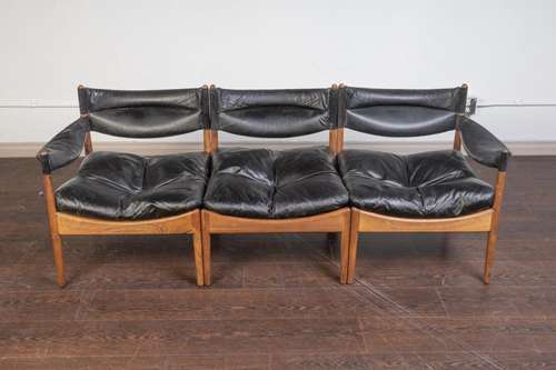 A Modus rosewood and black leather three seat sofa