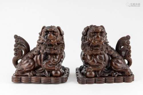 A pair of carved wood foo dogs, 9 in. (23 cm) h.