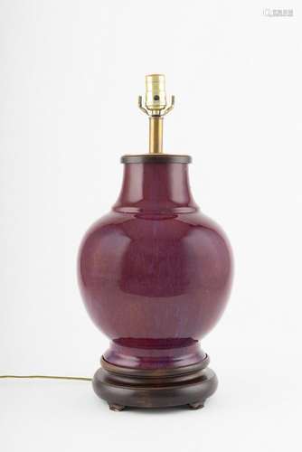 A burgundy ceramic table lamp.