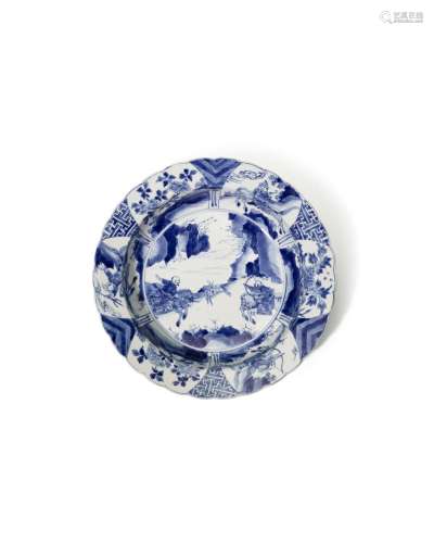 A FINE BLUE AND WHITE DISH WITH RIDERS IN THE CAVETTO Kangxi...