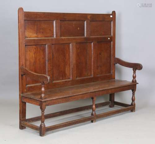 A George III provincial oak panel back hall bench with solid...