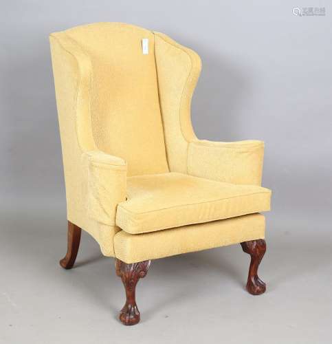 A mid-20th century George III style wing back armchair