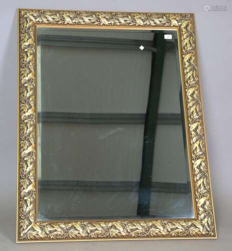 A modern gilt composition rectangular wall mirror with a bev...