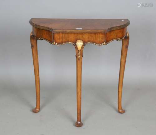 A mid-20th century walnut and gilded demi-lune side table wi...
