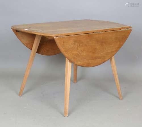 An Ercol elm drop-flap oval kitchen table