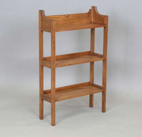 An Edwardian Arts and Crafts oak three-tier open bookcase, a...