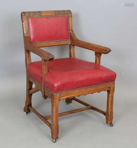 A late Victorian Gothic Revival oak framed elbow chair, in t...