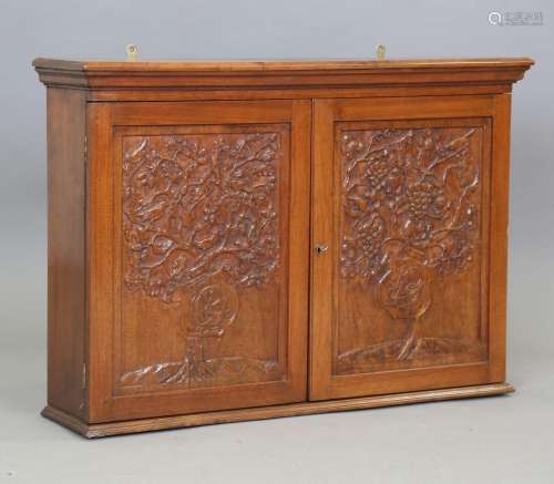 An early 20th century Arts and Crafts walnut wall cabinet, t...