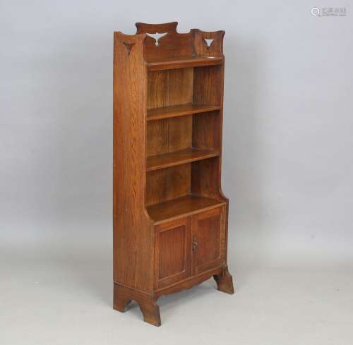 An Edwardian Arts and Crafts oak open bookcase, in the manne...