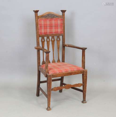An Edwardian Arts and Crafts oak framed elbow chair, the bac...