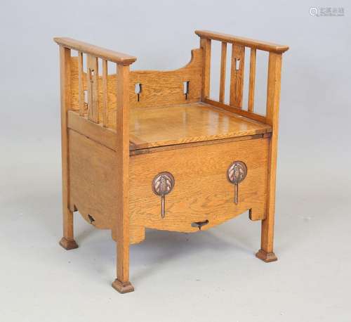 An Edwardian Arts and Crafts oak bedroom chair commode, the ...