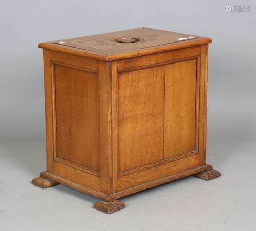 An early 20th century Arts and Crafts oak cellarette, the re...