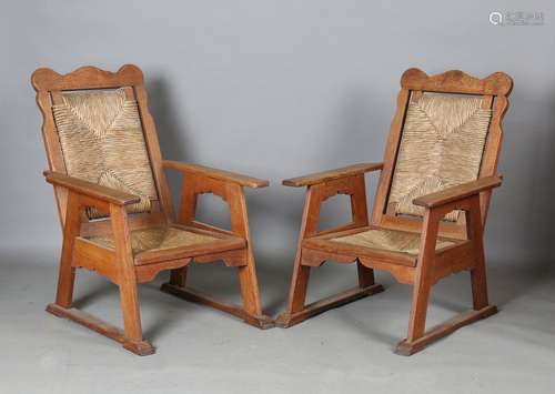 A pair of early 20th century Arts and Crafts oak framed armc...