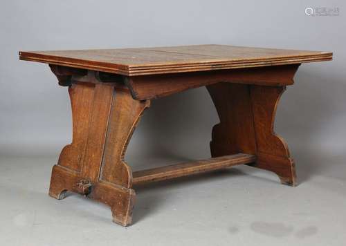 An early 20th century Arts and Crafts oak drawleaf dining ta...