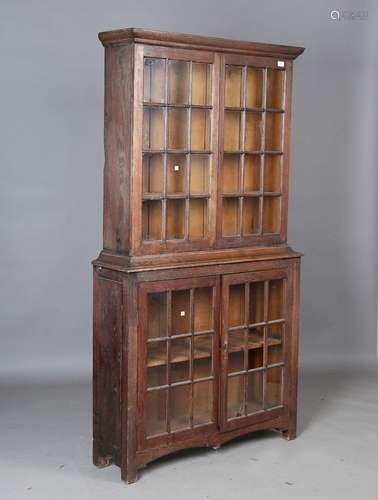 An early 20th century Arts and Crafts oak bookcase cabinet, ...