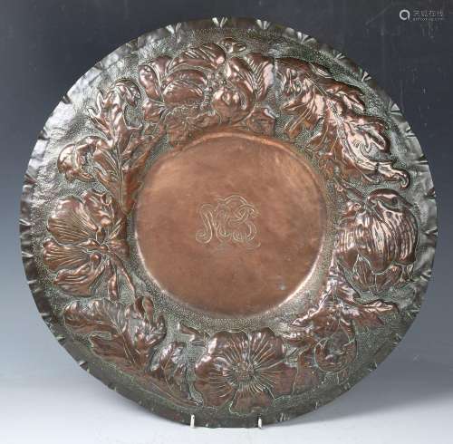 A late 19th century Arts and Crafts copper charger, the wide...