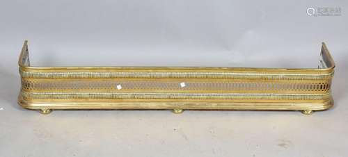 A Victorian brass fender with pierced frieze and bun feet, h...