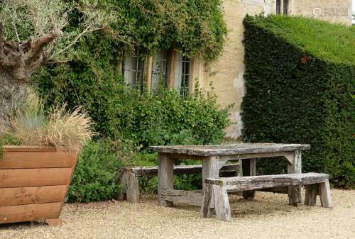 A WEATHERED 'SLEEPER' WOOD GARDEN TABLE AND A PAIR OF BENCHE...