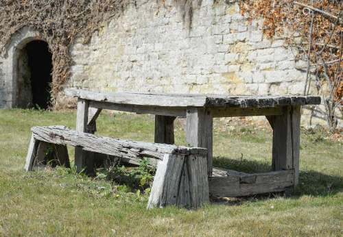 A WEATHERED 'SLEEPER' WOOD GARDEN TABLE AND A BENCH, 20TH CE...