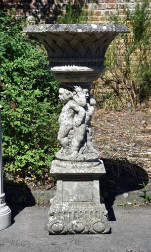 A COMPOSITION STONE 'WICKER' URN ON STAND, IN THE HADDONSTON...