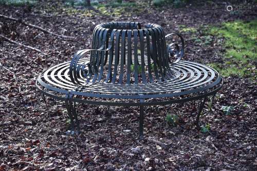 A PATINATED METAL PARK OR TREE SEAT, IN REGENCY STYLE, MODER...